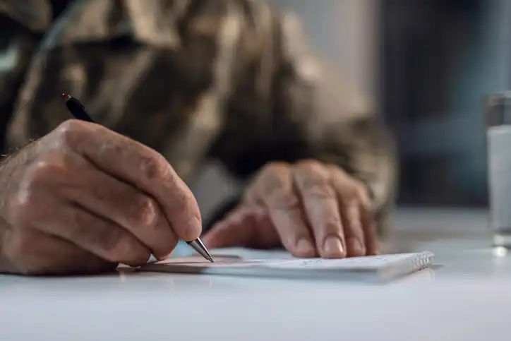 Camp Lejeune Veteran signing lawsuit settlement agreement