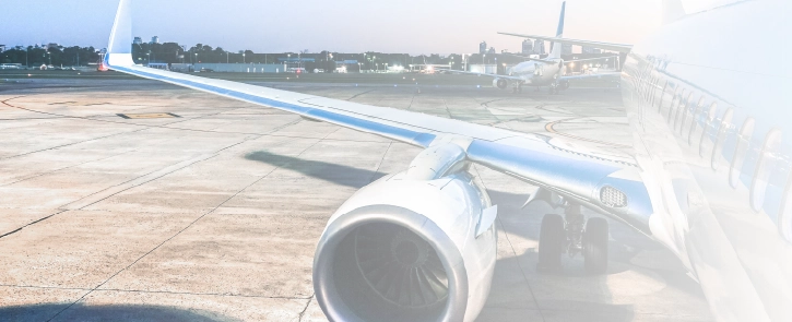 A commercial aircraft sits at an airport at dusk.